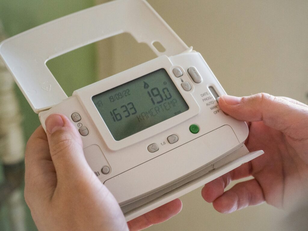 Air source heat pump maintenance - hands holding thermos